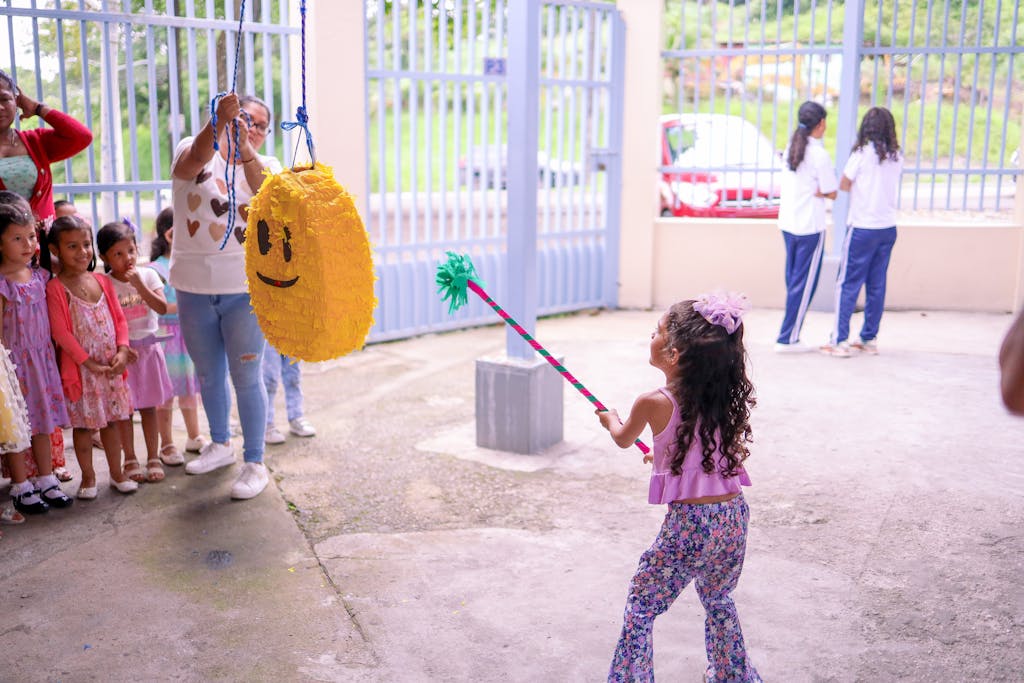 A little girl is holding a yellow balloon